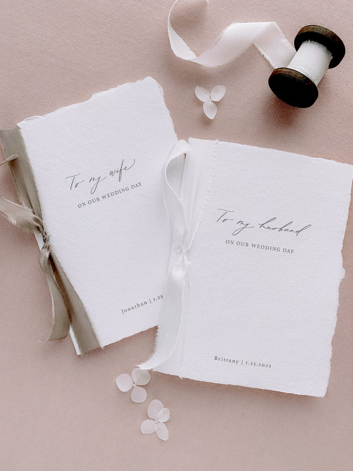 to my wife to my husband white wedding vow book with personalized names and date tied in silk ribbons 