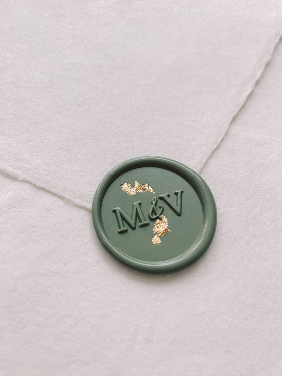 Typeface monogram round sage green custom wax seal embellished with gold flakes on beige handmade paper envelope