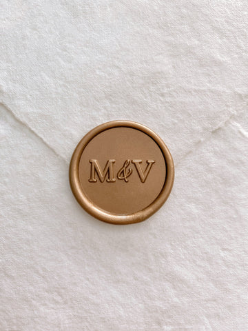 Typeface monogram round wax seal in gold on handmade paper envelope_front angle