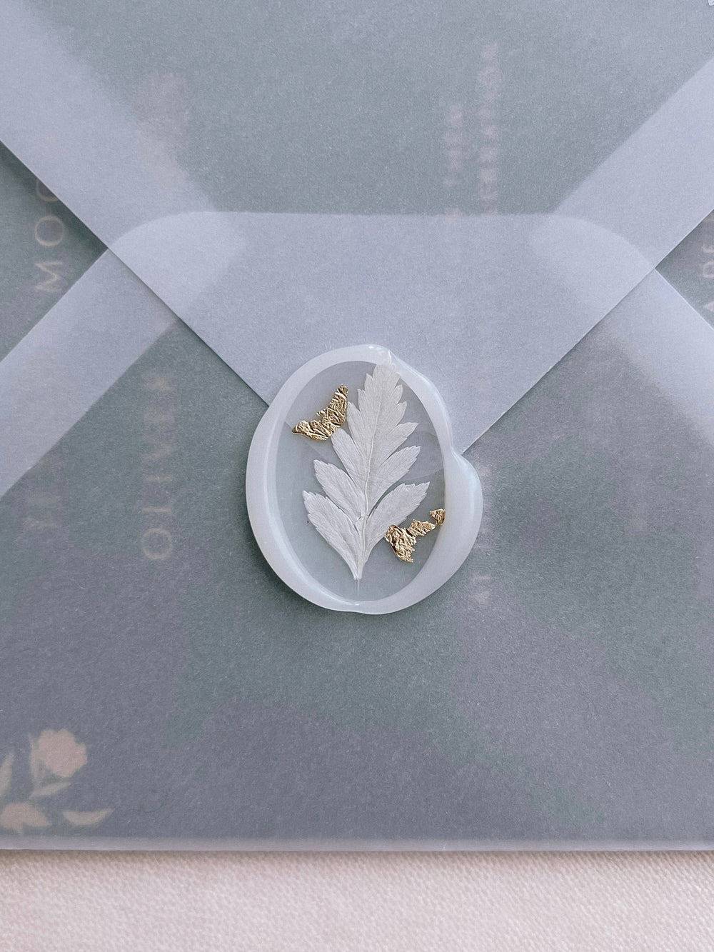 semi-transparent vellum wax seal decorated with dried leaf and gold leaf