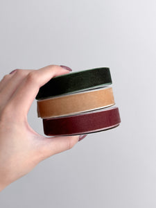 three rolls of velvet ribbon in green, gold and rust