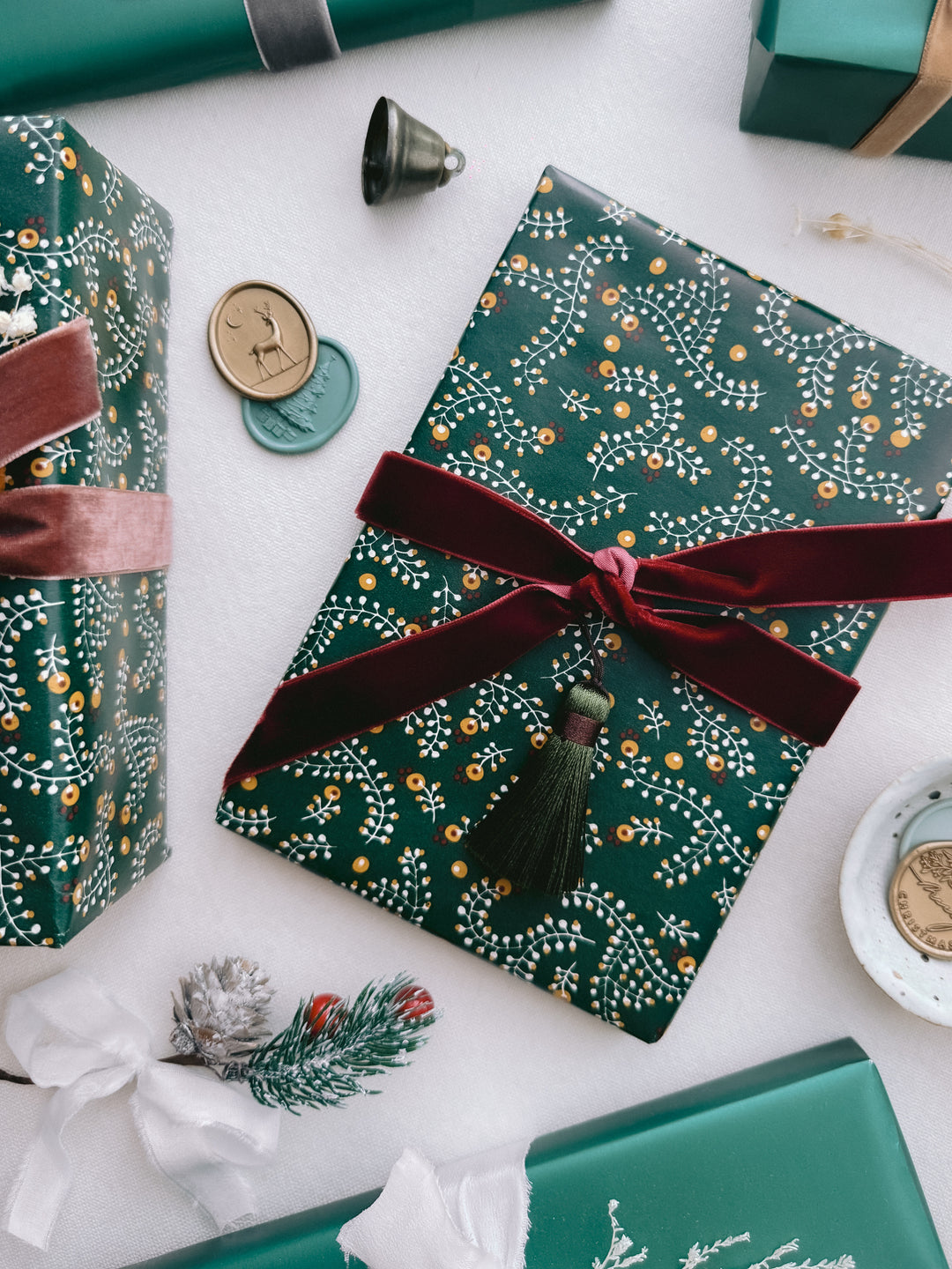 Christmas gift wrap decorated with dark red velvet ribbon bow and an olive green colored tassel