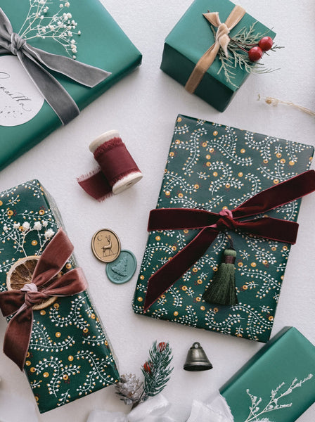 Christmas gifts wrapped in festive wrapping paper decorated with velvet ribbons