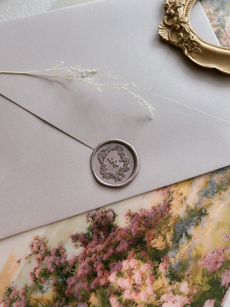 bronze colored vintage crest custom monogram wax seal on a beige envelope 