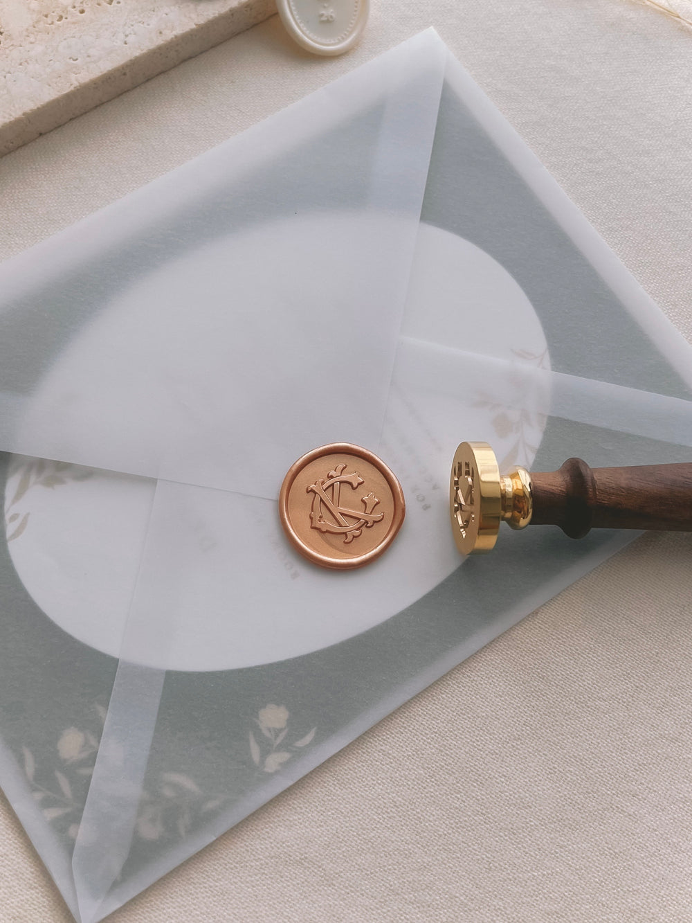 peachy gold colored custom vintage monogram wax seal on a wedding invitation envelope