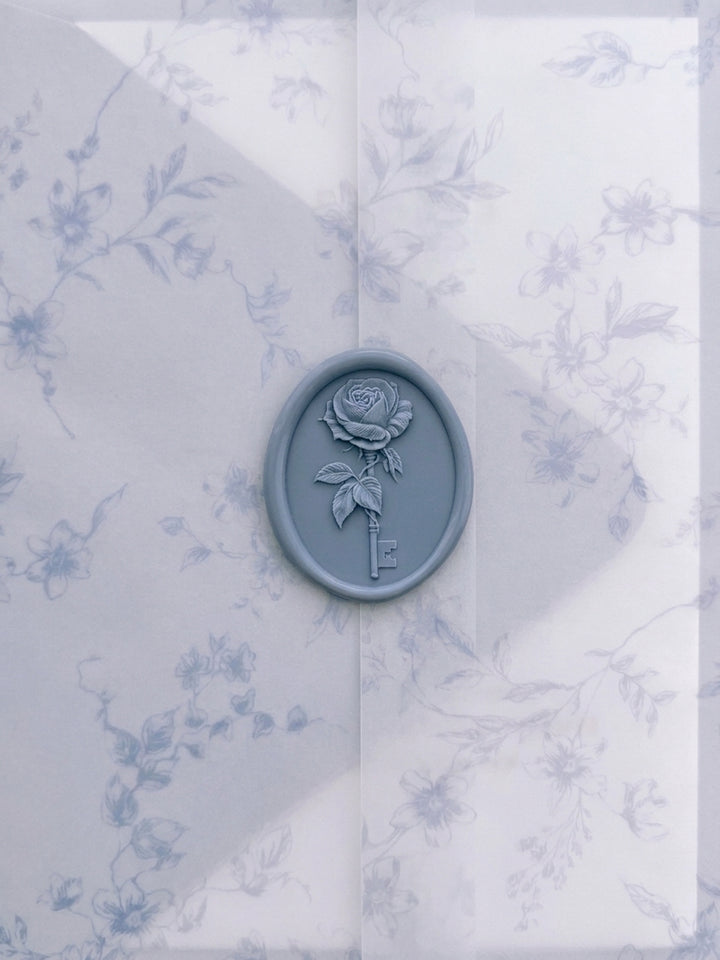 Dusty blue vintage rose key oval wax seal on a blue botanical print vellum jacket