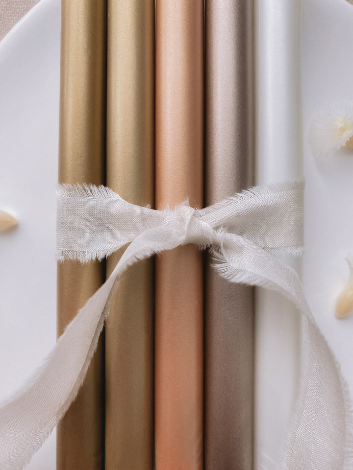 a set of 5 metallic earthy tones glue gun sealing wax sticks in gold, light gold, peachy gold, mocha, white pearl colors tied with soft white silk ribbon