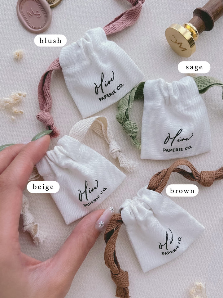 wax stamp head cotton storage pouches with color labels — pink, green, beige, and brown