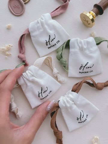 wax stamp head cotton storage pouches in different drawstring colors — pink, green, beige, and brown