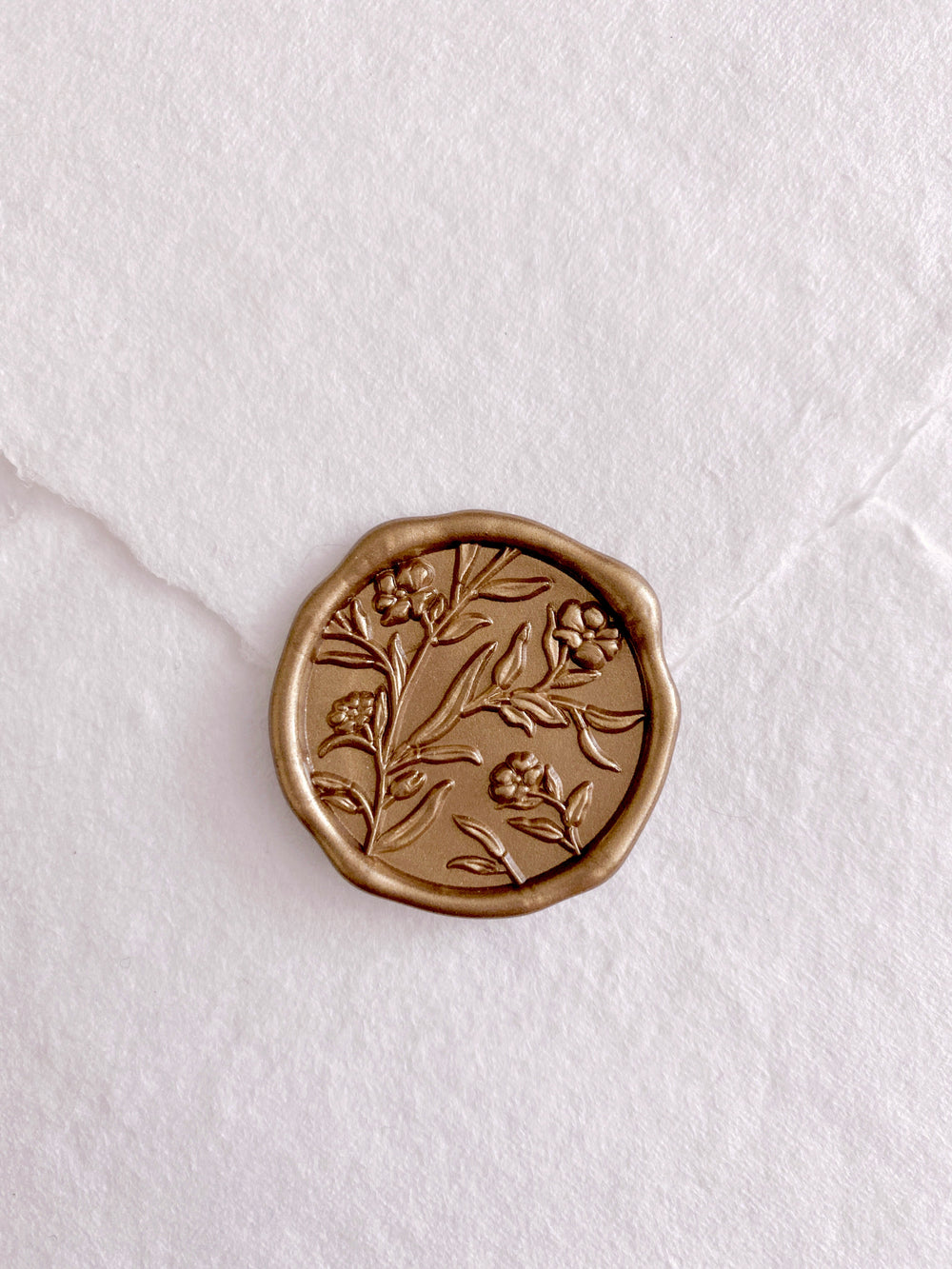 3D flower design gold wax seal on a white envelope 