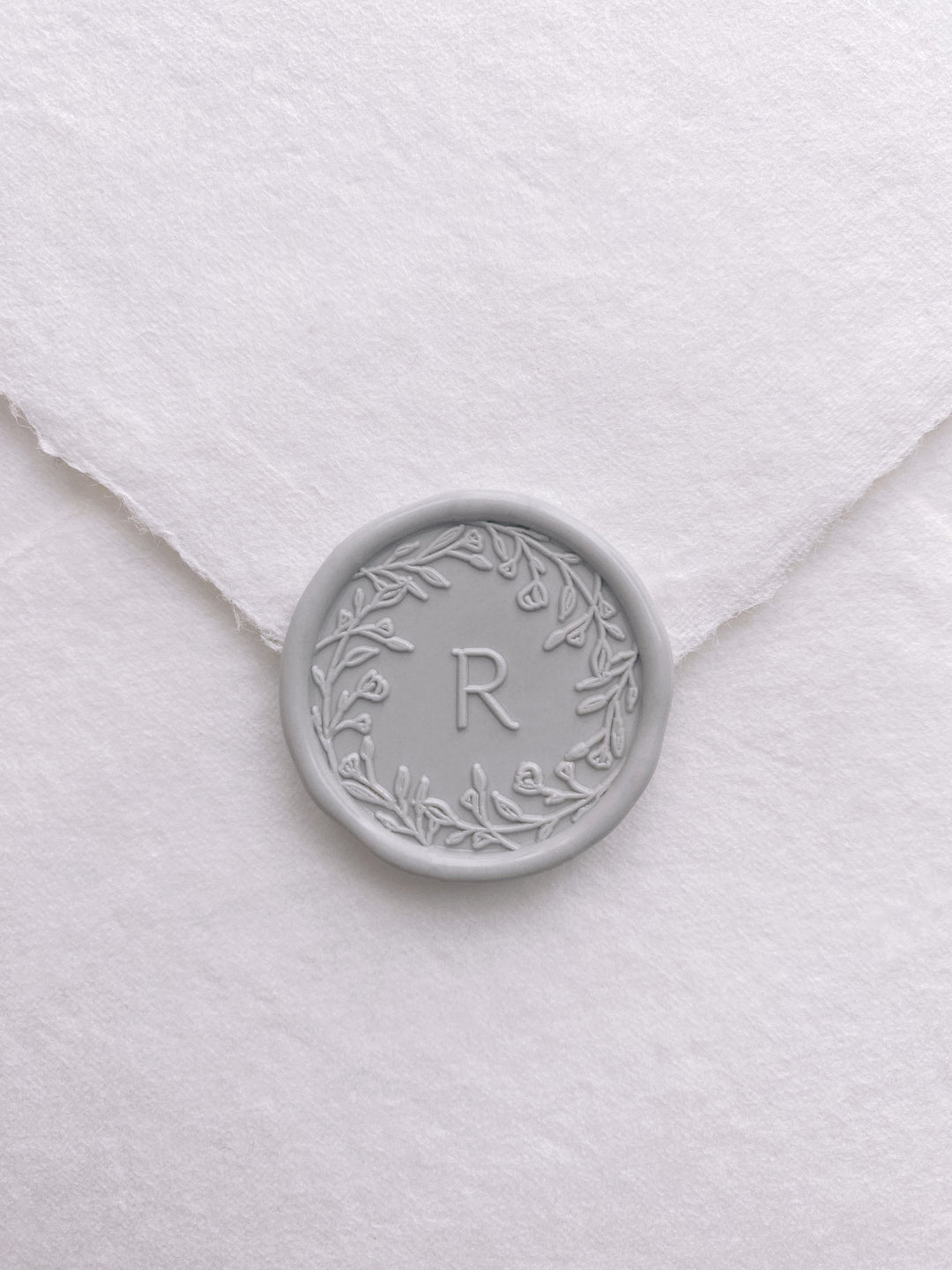 Floral crown single initial wax seal in light gray on handmade paper envelope_front angle