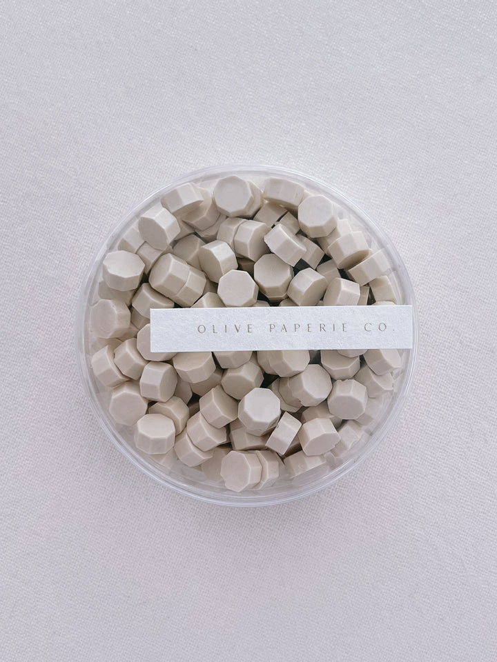 Light beige sealing wax beads in a clear container box