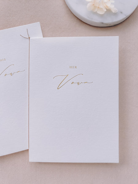 A set of two His and Her gold foil white vow books in calligraphy script with fine brown twine