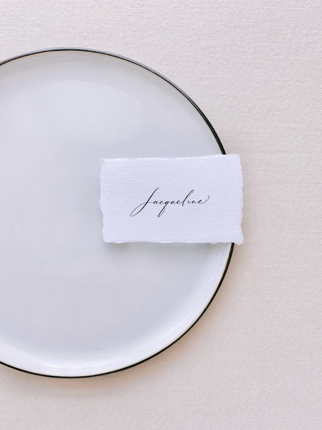 handmade paper place card in white color hand lettered in modern calligraphy in black ink_front angle