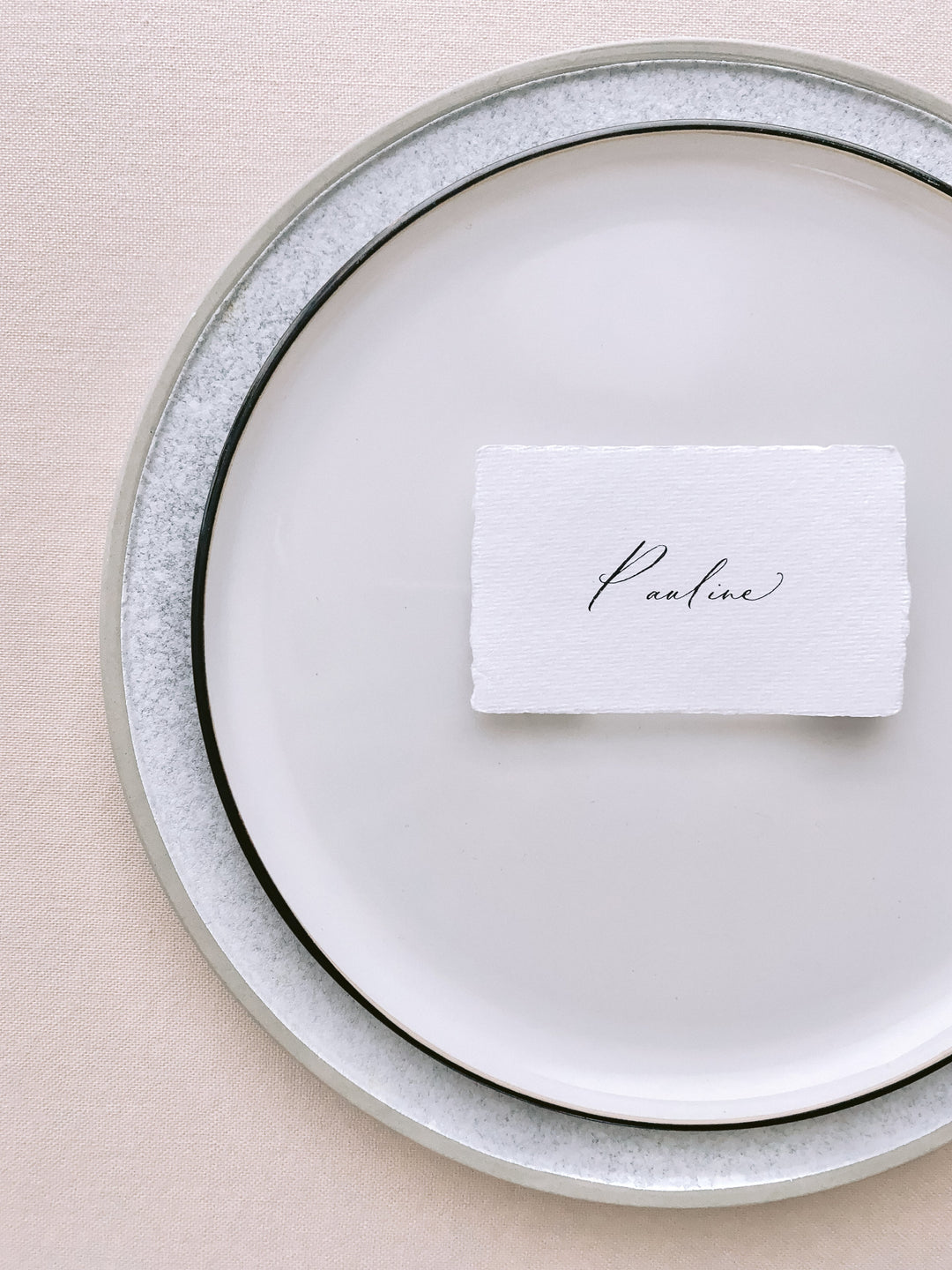 handmade paper place card in white color hand lettered in modern calligraphy in black ink